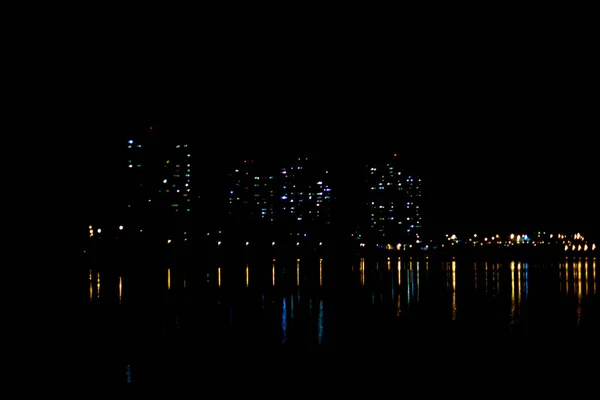 Światła miejskie odbijają się w wodzie. — Zdjęcie stockowe