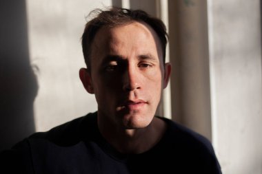 Pencereden yansıyan ışıktaki bir adamın portresi..