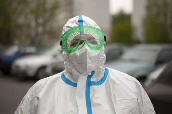 A doctor in a protective suit, glasses and a mask.