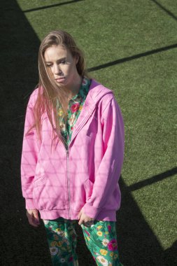 Yeşil arka planda pembe kazaklı bir manken.