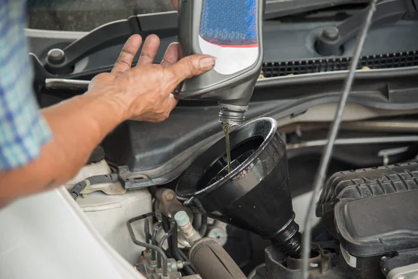Mechanik pojmania oleju silnika z samochodu do wymiany oleju w sklepie samochodowym — Zdjęcie stockowe