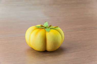 Ahşap arka plan üzerinde küçük turuncu kabak heykel