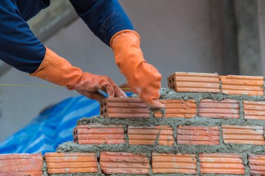 İşçi inşaat alanına kırmızı tuğla yüklüyor