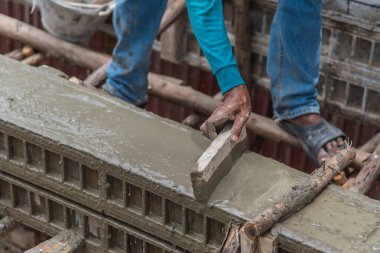 İnşaat alanında işçi alçısı. Ticari beton döşeme sırasında beton dökülüyor..
