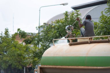 İşçi ıslak sokağın basınçlı suyla temizlenmesi.