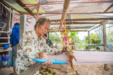Nadun, Maha Sarakham, Tayland - 9 Mart 2018: Tayland 'da geleneksel Tayland kumaşı ören kadınlar. Nadun, Maha Sarakham, Tayland