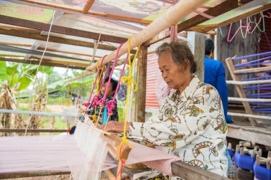 Nadun, Maha Sarakham, Tayland - 9 Mart 2018: Tayland 'da geleneksel Tayland kumaşı ören kadınlar. Nadun, Maha Sarakham, Tayland