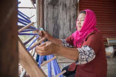 Nadun, Maha Sarakham, Tayland - 9 Mart 2018: Tayland 'da geleneksel Tayland kumaşı ören kadınlar. Nadun, Maha Sarakham, Tayland
