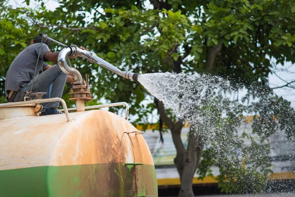 Wet cleaning of street with pressurized water.