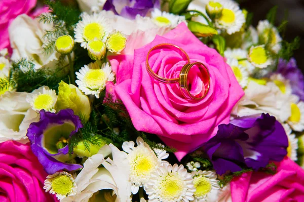 Anillos de bodas de oro que yacen cerca de flores —  Fotos de Stock