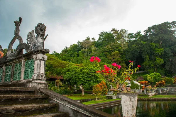 Uma ponte artificial com quatro estátuas de dragões com caudas torcidas, parque Tirta Gangga, Karangasem, Bali, Indonésia — Fotografia de Stock