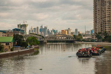 Köprünün diğer tarafında nehir ve gökdelenler görünümden. Manila, Filipinler.