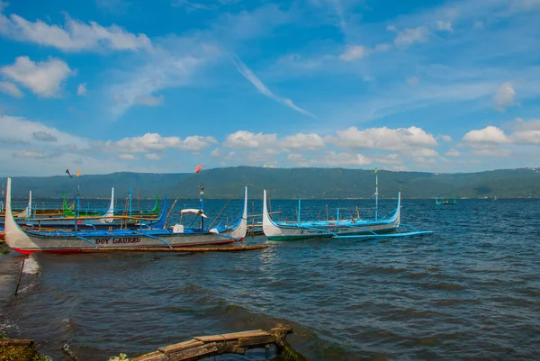 Plusieurs bateaux traditionnels philippins Outrigger ou banca amarrés à une jetée en bois sur la rive du lac Taal, Tagaytay Philippines . — Photo