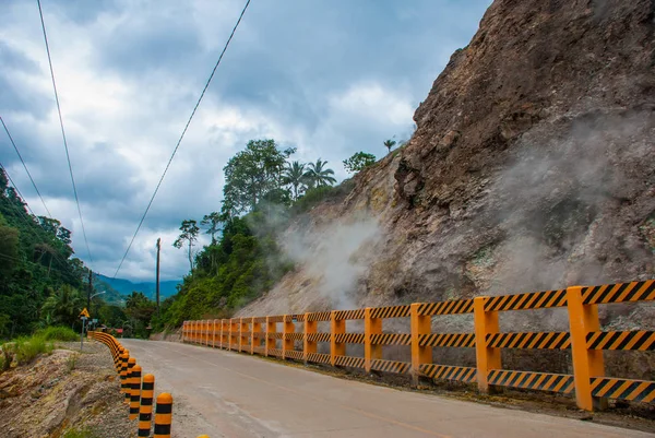 Vapor blanco de la montaña del volcán y cruzar la carretera. Filipinas. Valencia, isla Negros . — Foto de Stock