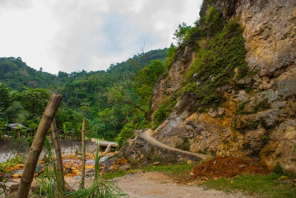 Broken concrete road with stones in the summer. Philippines. Valencia, island Negros.