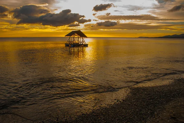 Bellissimo tramonto sulla spiaggia. Silhouette di padiglioni. Pandan, Panay, Filippine . — Foto Stock