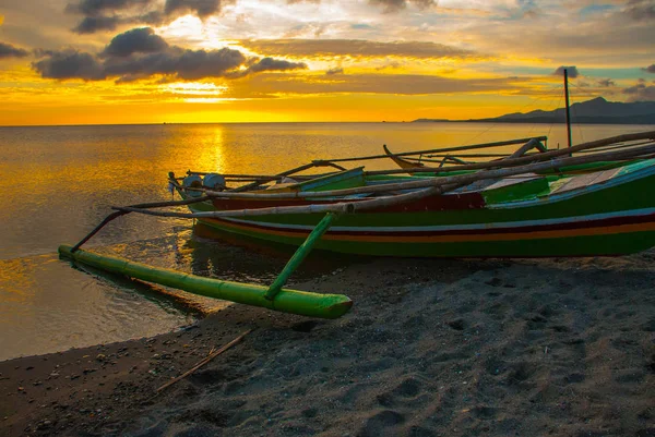 ビーチに沈む夕日。ローカルのボートで岸に立っています。パンダン、パナイ島、フィリピン. — ストック写真