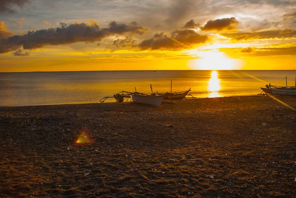 ビーチに沈む夕日。ローカルのボートで岸に立っています。パンダン、パナイ島、フィリピン. — ストック写真