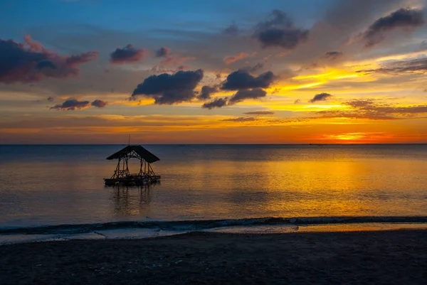 ビーチに沈む夕日。パビリオンのシルエット。パンダン、パナイ島、フィリピン. — ストック写真