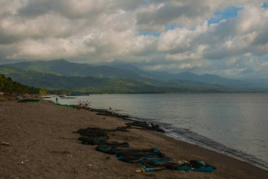 Gökyüzü manzara ile bulutlar, volkanik kum plaj. Pandan, Panay, Filipinler.