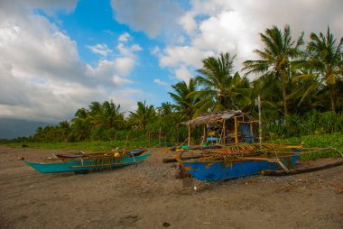 Bulutlar, dağlar bulutlu havalarda ile gökyüzü manzara. Volkanik kumlu plaj tekne ile. Pandan, Panay, Filipinler.