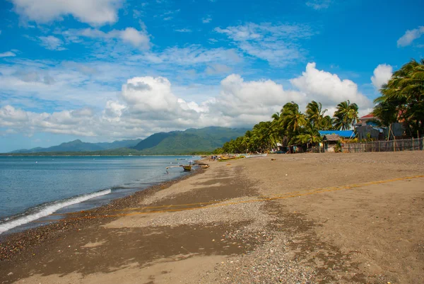 Sea, palm trees, mountains on the volcanic beach. Pandan, Panay, Philippines. — Stock Photo, Image