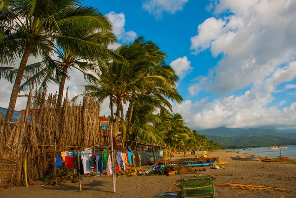 Красочная одежда, высыхающая на веревке на пляже среди пальм. Пандан, Панай, Филиппины . — стоковое фото