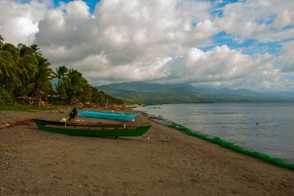 Krajina obloha s mraky, hory v oblačné počasí. Vulkanické písečná pláž s čluny. Pandan, Panay, Filipíny. — Stock fotografie