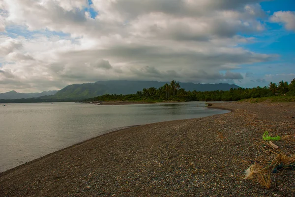 Landscape sky with clouds, volcanic sand on the beach. Pandan, Panay, Philippines. — Stock Photo, Image