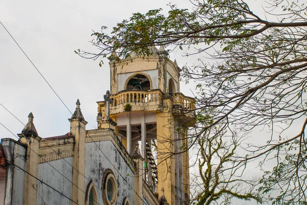 Cathédrale catholique sur fond de branches d'arbres aux Philippines. Pandan, Panay — Photo