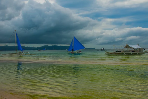 Парусник с голубым парусом на фоне облаков, остров Боракай, Филиппины — стоковое фото