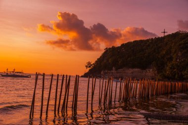Tropikal peyzaj gün batımında. Çit ve deniz. Beyaz plaj. Boracay. Filipinler.
