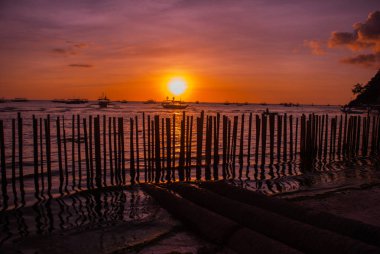 Tropikal peyzaj gün batımında. Çit ve deniz. Beyaz plaj. Boracay. Filipinler.