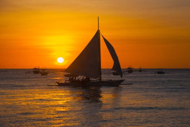 Teknelerden tropikal ülkede, bulutlar ile dramatik turuncu deniz günbatımı. Filipinler, Boracay