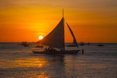 Teknelerden tropikal ülkede, bulutlar ile dramatik turuncu deniz günbatımı. Filipinler, Boracay