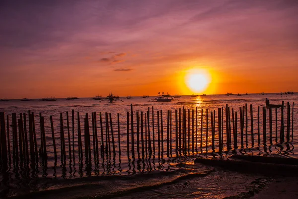 Tropikal peyzaj gün batımında. Çit ve deniz. Beyaz plaj. Boracay. Filipinler.