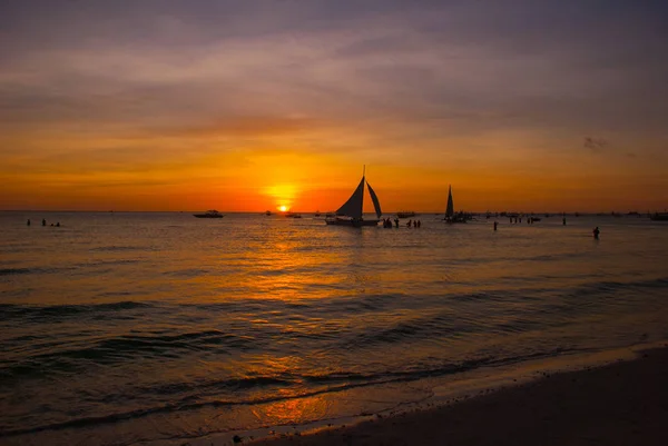 Dramática puesta de sol del mar naranja con veleros en el país tropical, nubes. Filipinas, Boracay — Foto de Stock
