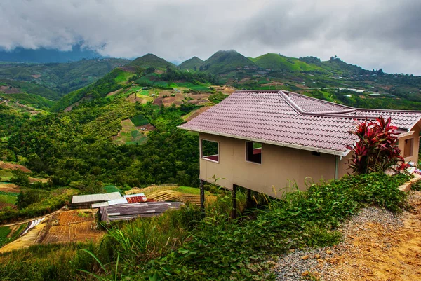Το δρόμο και τα σπίτια του χωριού στις πλαγιές των βουνών με τα σύννεφα. Sabah, Μπόρνεο, Μαλαισία. — Φωτογραφία Αρχείου