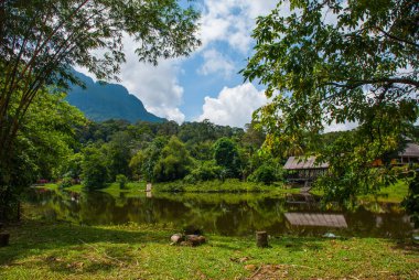 Geleneksel ahşap ev göl ve dağ içinde belgili tanımlık geçmiş. Kuching Sarawak kültür köyü. Borneo, Malezya