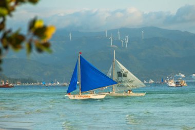 Bulutlar, Boracay Adası, Filipinler bir arka plan üzerinde mavi bir yelken yelkenli tekne