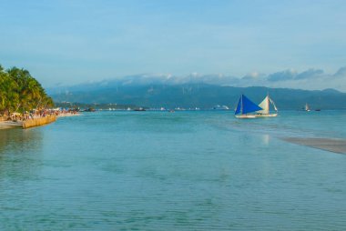 Bulutlar, Boracay Adası, Filipinler bir arka plan üzerinde mavi bir yelken yelkenli tekne