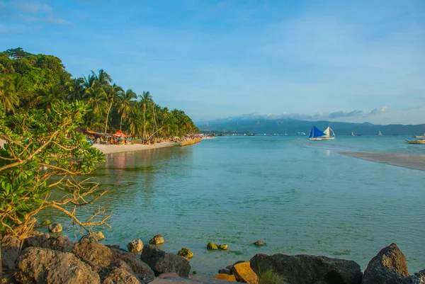 Bulutlar, Boracay Adası, Filipinler bir arka plan üzerinde mavi bir yelken yelkenli tekne