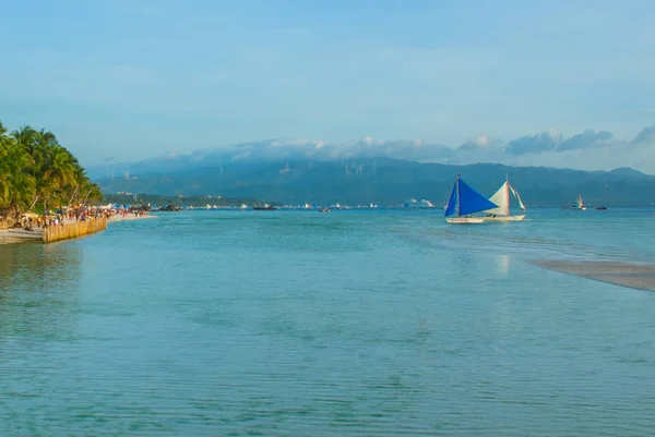 Barca a vela con una vela blu su uno sfondo di nuvole, Isola di Boracay, Filippine — Foto Stock