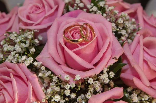 Anillos de boda y ramo de rosas rosadas . — Foto de Stock