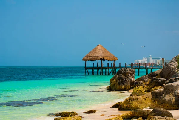 Pier och trä lusthus vid stranden. Tropiskt landskap med brygga: hav, sand, klippor, vågor, turkost vatten. Mexiko, Cancun — Stockfoto