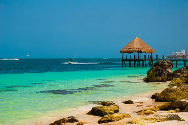Pier och trä lusthus vid stranden. Tropiskt landskap med brygga: hav, sand, klippor, vågor, turkost vatten. Mexiko, Cancun — Stockfoto