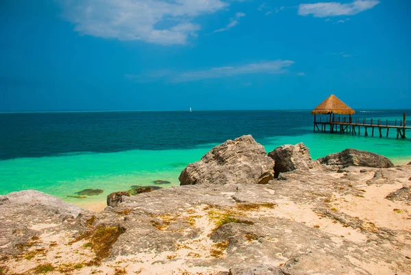 Molo e gazebo in legno vicino alla spiaggia. Paesaggio tropicale con pontile: mare, sabbia, rocce, onde, acqua turchese. Messico, Cancun — Foto Stock