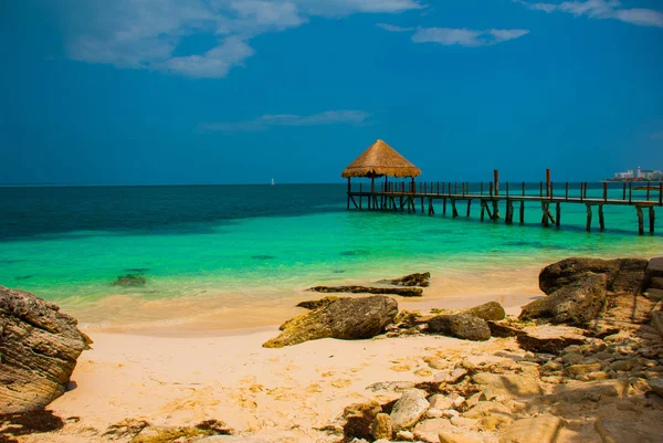 İskele ve plajda ahşap çardak. İskelesi ile tropikal manzara: Deniz, kum, kaya, dalgalar, turkuaz su. Meksika, Cancun — Stok fotoğraf