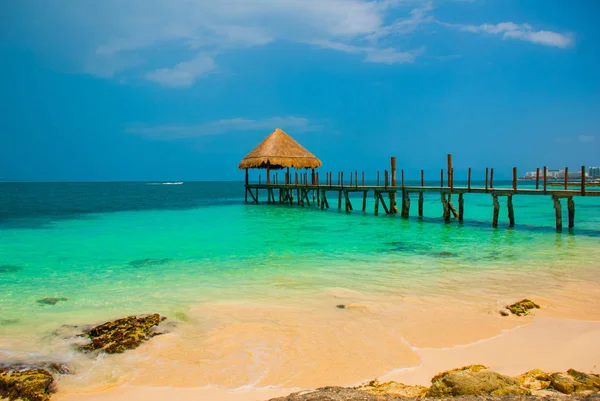 Molo i drewniana altana na plaży. Tropikalny krajobraz z molo: morze, piasek, skały, fale, turkusowa woda. Meksyk, Cancun — Zdjęcie stockowe