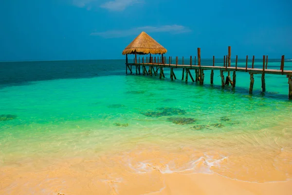 İskele ve plajda ahşap çardak. İskelesi ile tropikal manzara: Deniz, kum, kaya, dalgalar, turkuaz su. Meksika, Cancun — Stok fotoğraf